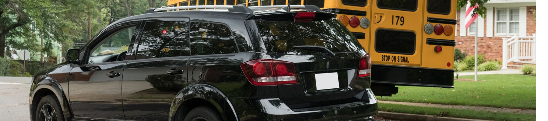 Image of car driving around school bus
