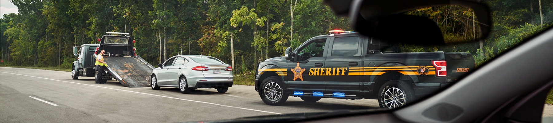 Car pulled over with tow truck and police vehicl