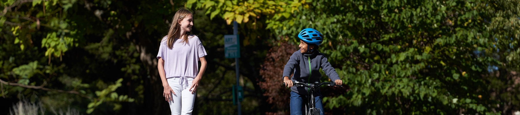 Two young pedestrians traveling on the side of the road