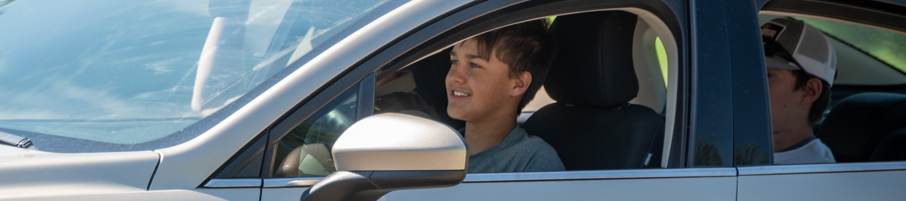 Young male driver in a car with friends
