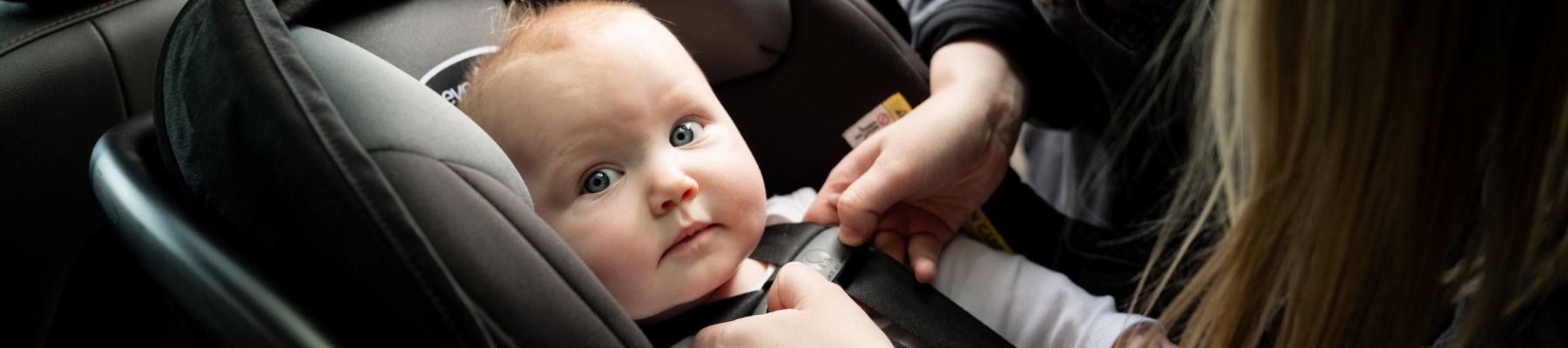 Child being buckled into a carseat